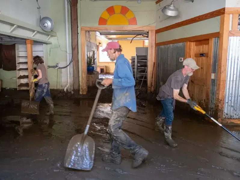 Flood mud being shoveled out of a building during flood water cleanup